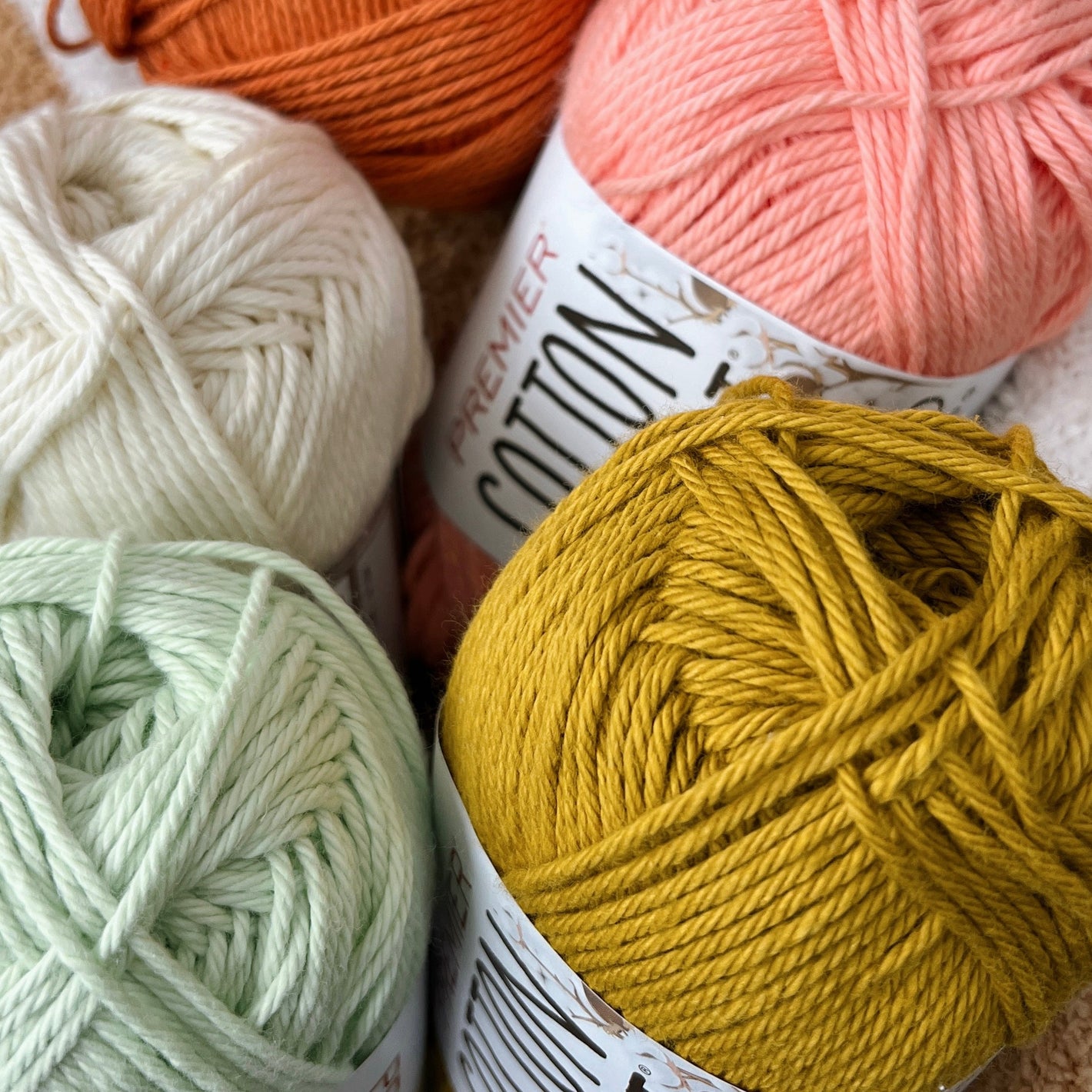 Four balls of yarn in different colors with visible labels.
